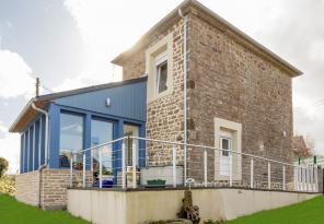 Vue extérieure d’une maison rénovée avec extension véranda